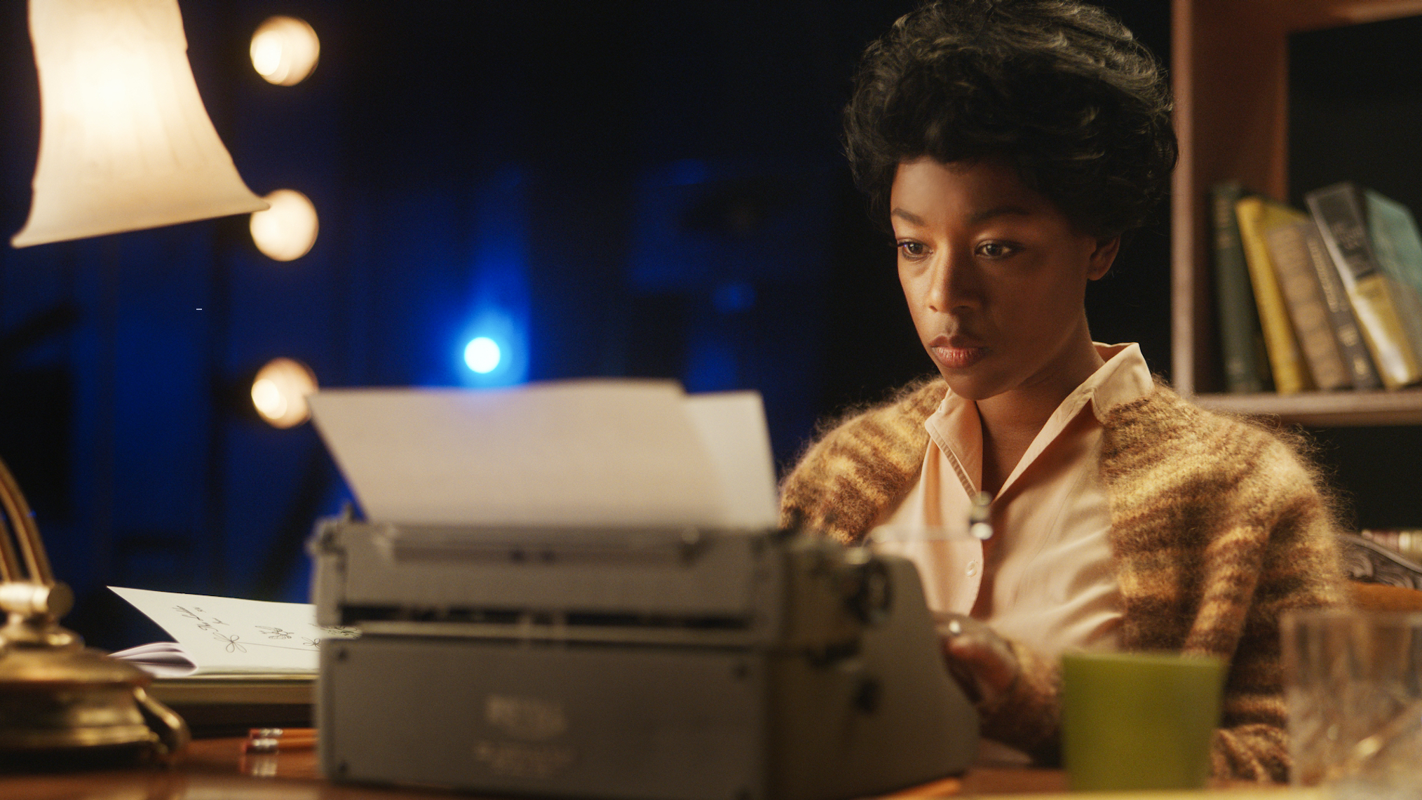 Photo of Samira Wiley working at an electric typewriter, enacting Lorraine Hansberry in a scene from HBO Max's four-part docuseries, EQUAL.